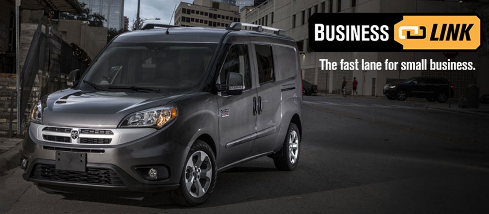 A gray Ram ProMaster City cargo van is parked on a city