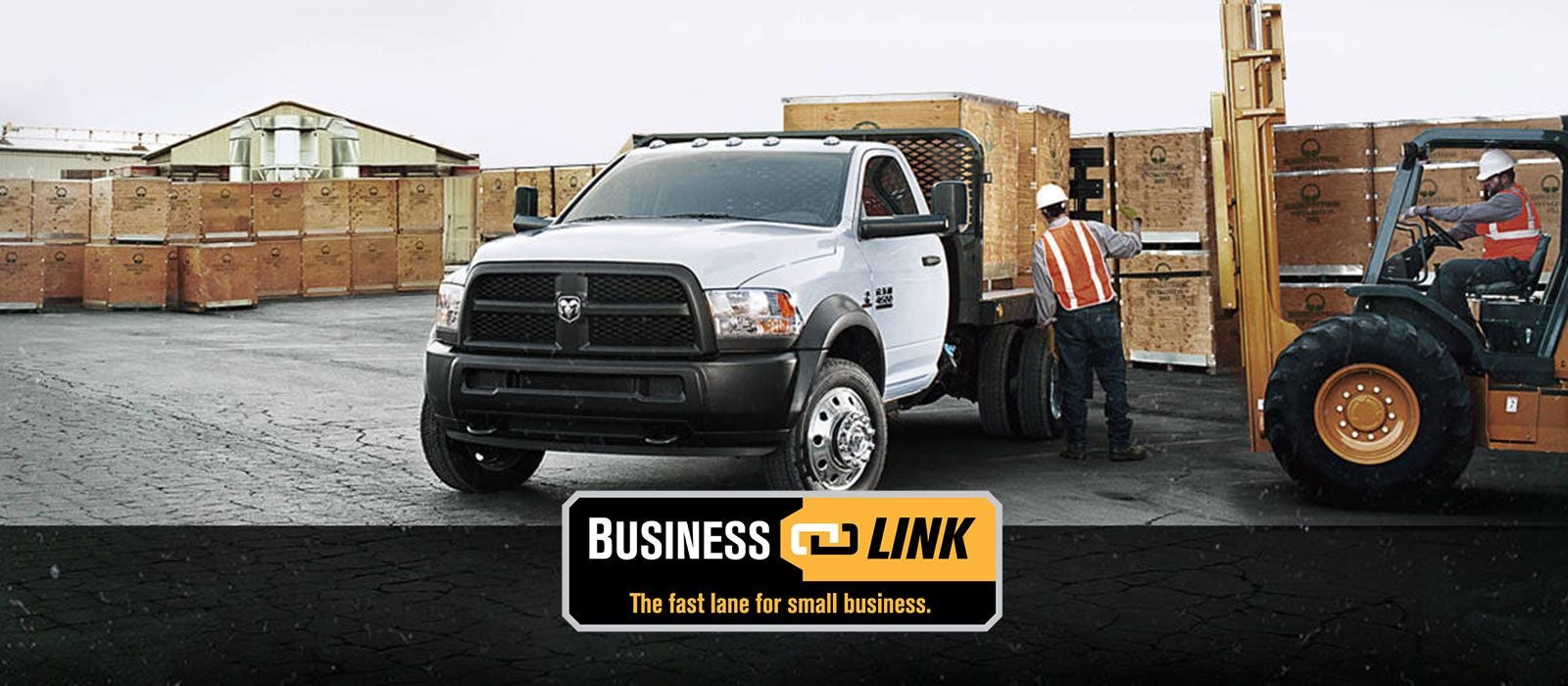 A white flatbed truck with workers and a forklift loading equipment