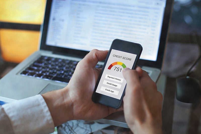 Hands holding a smartphone displaying a credit score