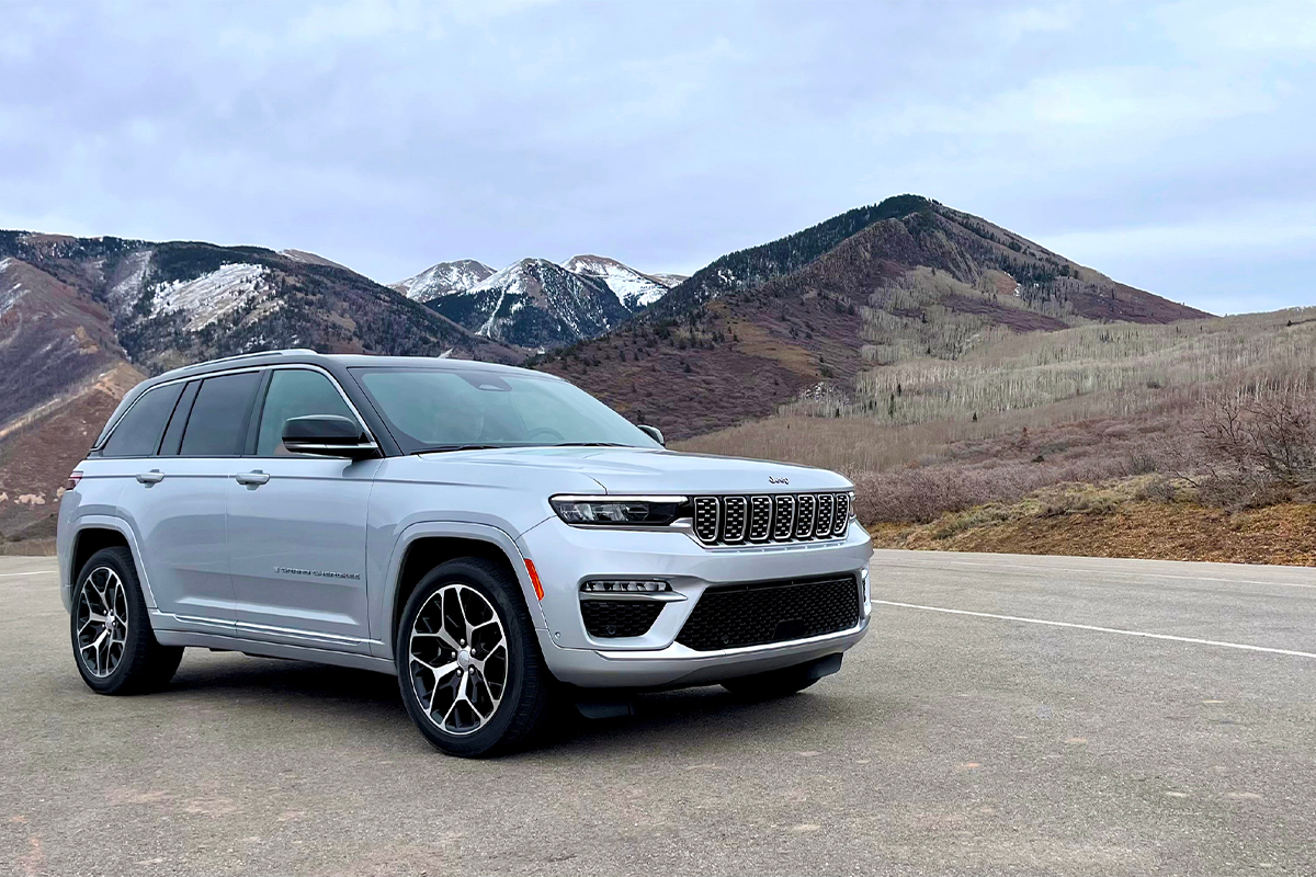 A Jeep Grand Cherokee parked near mountains.